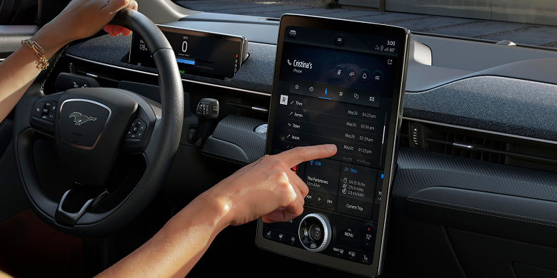 Hand using the Ford Mustang Mach-E center touchscreen in the car